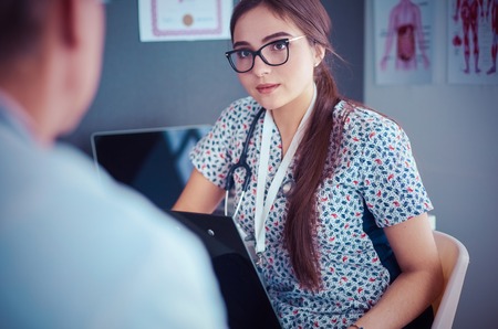 Two doctors speaking in a bright officeの写真素材