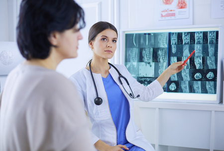 Medical consultation. Female doctor holding a patient by her shoulder, soothing her fearの写真素材