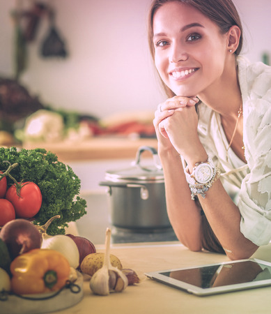 Young woman using a tablet computer to cook in her kitchenの写真素材