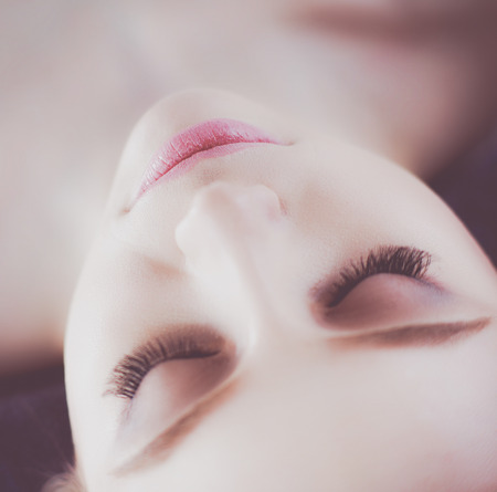 Young woman lying on a massage table,relaxing with eyes closed. Woman. Spa salonの写真素材