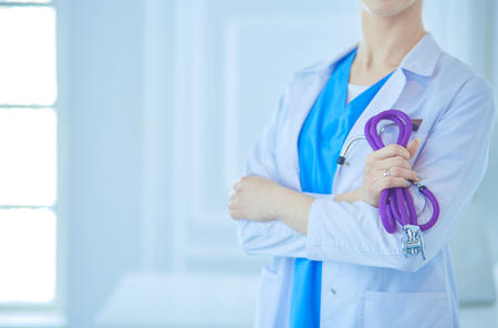 Cheerful happy doctor with crossed hands on blue backgroundの写真素材
