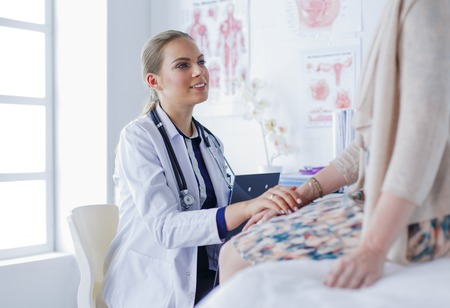 Doctor and patient discussing something while sitting at the table . Medicine and health care conceptの写真素材