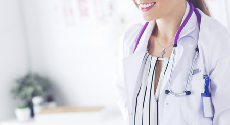 Smiling female doctor with a medical stethoscope in uniform standingの写真素材