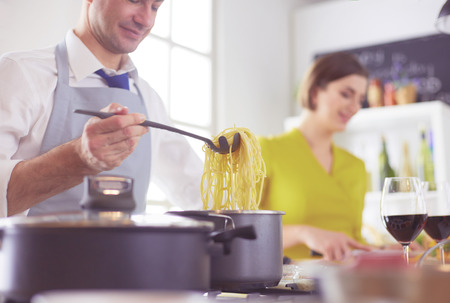 Couple cooking together in the kitchen at homeの写真素材