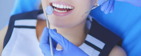Young Female patient with open mouth examining dental inspection at dentist office.の写真素材