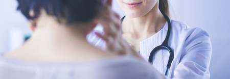 A serious female doctor examining a patients lymph nodesの写真素材