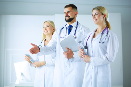 Male doctor offering handshake In Front Of His Colleaguesの写真素材