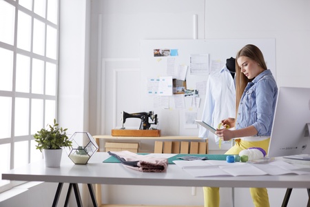 Fashion young designer woman measuring a dress.の写真素材