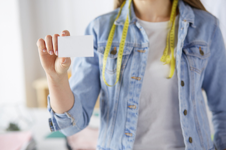 Young woman holding blank white business cardの写真素材