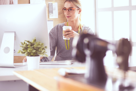 Fashion designer woman sewing with sewing machineの写真素材