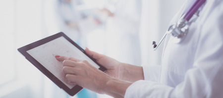 portrait of a young female doctor, with aipads in hand, in a medical officeの写真素材