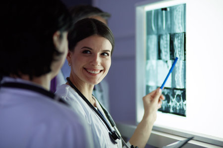 Group of doctors examining x-rays in a clinic, thinking of a diagnosis