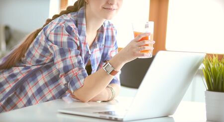 Beautiful young smiling female doctor sitting at the desk and writing.の写真素材
