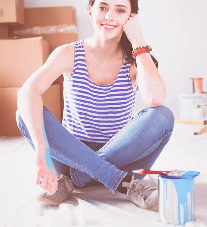 Happy smiling woman painting interior wall of new house. Happy smiling womanの写真素材