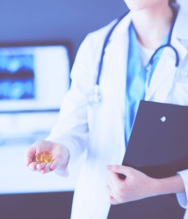 Close-up shot of doctors hands holding pills at clinic.の写真素材