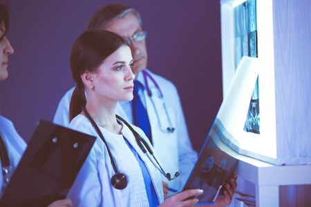 Hospital doctors looking at x-rays in an emergency roomの写真素材