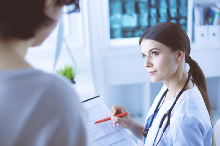 Beautiful female doctor explaining medical treatment to a patient