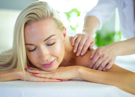Young woman enjoying massage in spa salonの写真素材