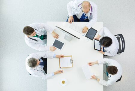 Medical team sitting and discussing at table, top viewの写真素材