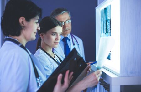 Hospital doctors looking at x-rays in an emergency roomの写真素材
