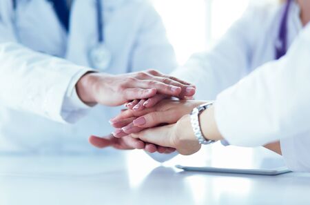 Team of doctors putting hands together, closeupの写真素材