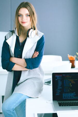 Young businesswoman standing in front of a table in the officeの写真素材