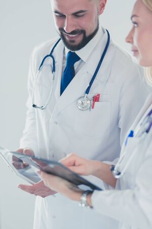 Two doctors holding a folder and talking about patientの写真素材