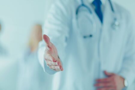 friendly male doctor with open hand ready for hugging.の写真素材