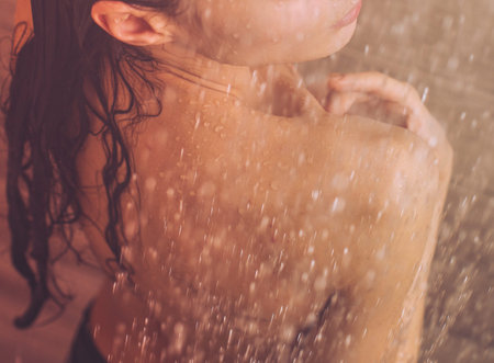 Young beautyful woman under shower in bathroom.
