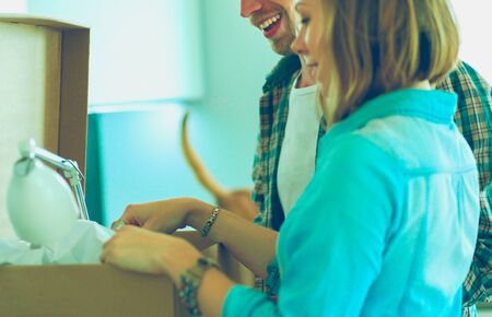 Young couple carrying big cardboard box at new home.Moving houseの写真素材