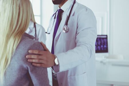 Handsome male doctor consulting a couple about infertility in his medical officeの写真素材