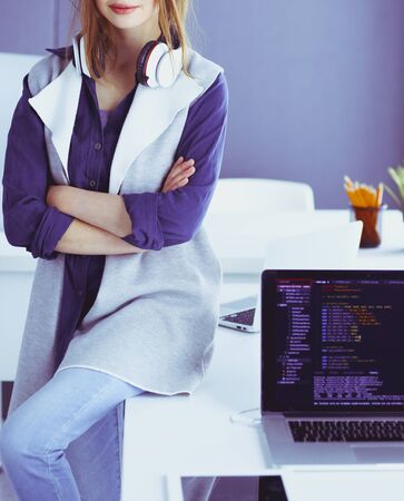 Young businesswoman standing in front of a table in the officeの写真素材
