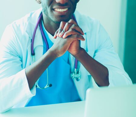 Portrait of young male doctor wearing headset while using computer at desk in clinic. Doctor.の写真素材