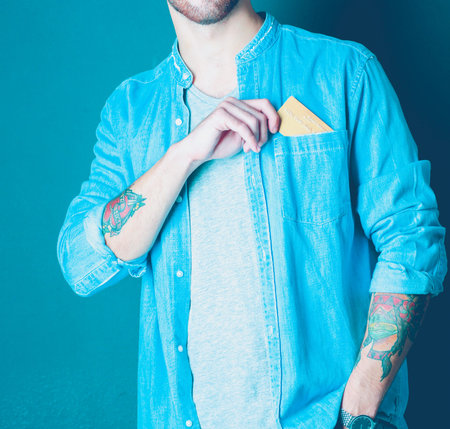 Man holding a credit card standing on gray background