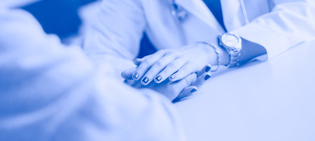Woman doctor helping senior holding hand in hospital