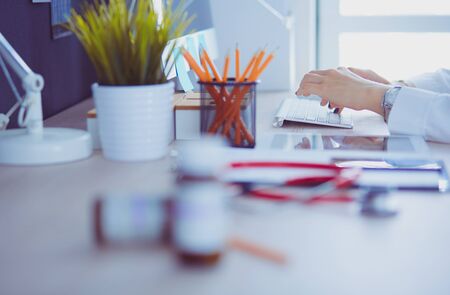 Female doctors hands using laptop at deskの写真素材