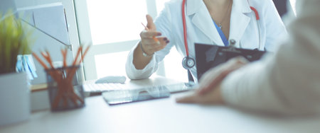 Female doctor holding application form while consulting patient.