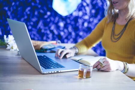 Young woman on a coffee break or enjoying the coffee-break, Using laptop computer.の写真素材