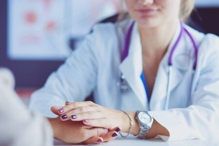 Woman doctor helping senior holding hand in hospital.の写真素材
