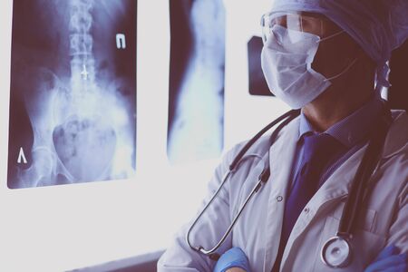 Young doctor looking X-Ray image on isolated white background.の写真素材