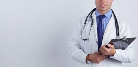 Male doctor standing with folder, isolated on white background.の写真素材
