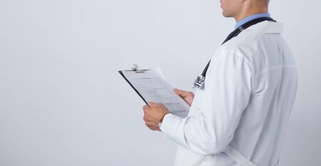 Male doctor standing with folder, isolated on white background.の写真素材