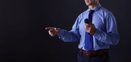 Man holding a microphone while pointing his finger at you.