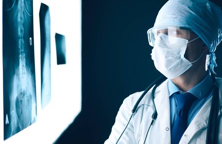 Young doctor looking X-Ray image on isolated white background.の写真素材