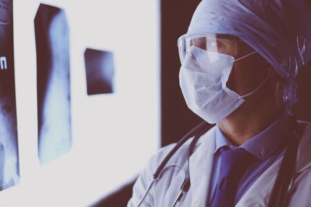 Young doctor looking X-Ray image on isolated white background.の写真素材