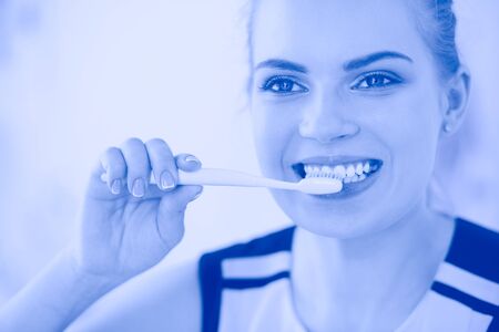 Young pretty girl maintaining oral hygiene with toothbrush.の写真素材