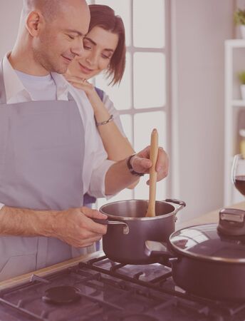 Couple cooking together in the kitchen at homeの写真素材
