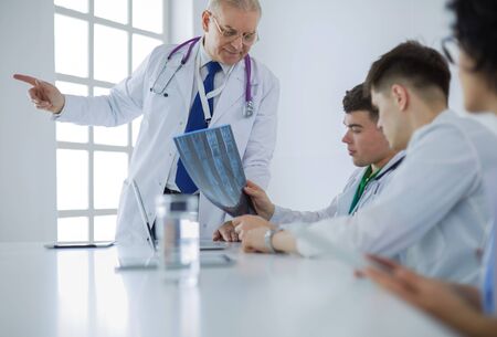 Medical team sitting and discussing at tableの写真素材
