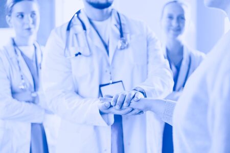 Doctors and nurses in a medical team stacking handsの写真素材