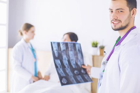 Medical team discussing diagnosis of x-ray image in officeの写真素材